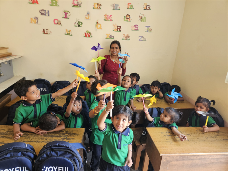 Children holding pinwheels in a Joyful School classroom in India